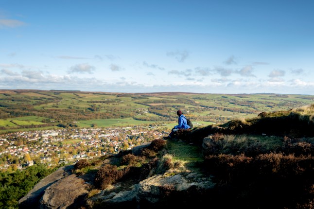 Person sits on top of the rocks on Ilkley Moor, West Yorkshire.