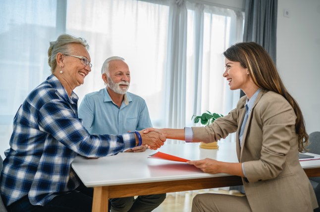 Senior couple shaking hands with financial advisor
